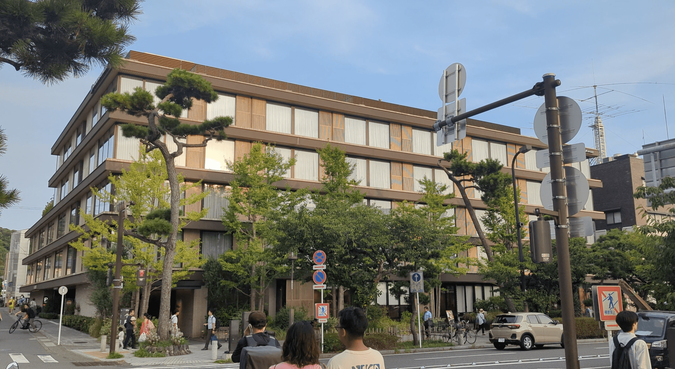 Exterior front view of Hotel Metropolitan Kamakura, a modern mid-rise hotel with clean architectural lines beside a garden and leafy street in Kamakura, Japan.