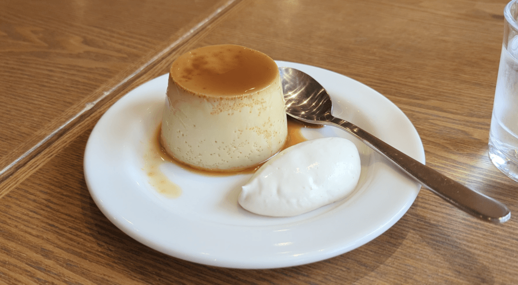 Close-up of MUJI Japanese pudding dessert with a silky custard texture, minimalist presentation, and natural lighting.